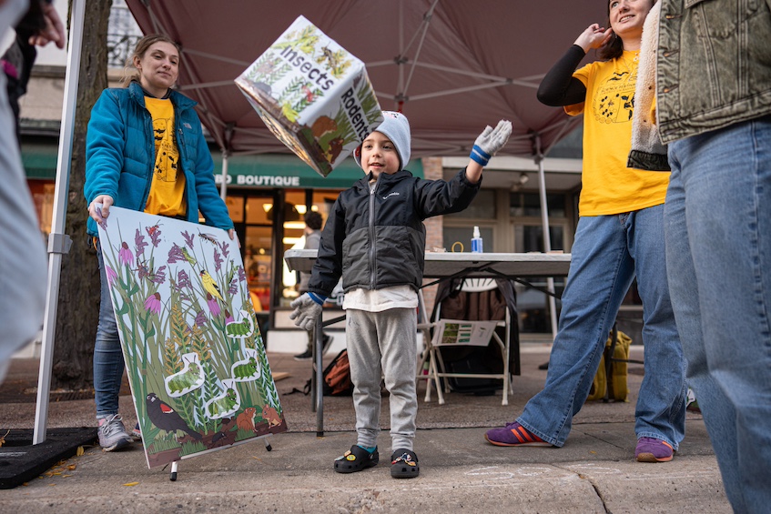 “Roll for Biodiversity” — A child at Science on the Square plays a game designed by the Great Lakes Bioenergy Center at the Wisconsin Energy Institute to simulate how biodiversity affects crop systems geared toward sustainable bioenergy solutions. (Photo by Romulo Ueda Photography)