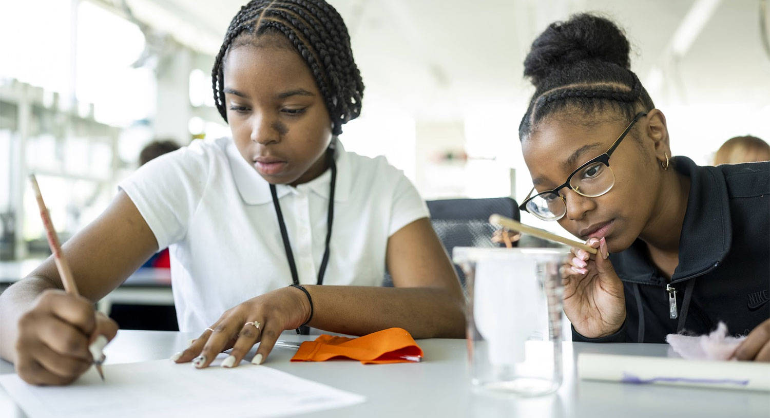 A middle school student using DIY electroscopes to test and measure the static charge of materials.